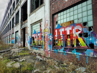 Urban ghetto building exterior with spray paint graffiti on brick