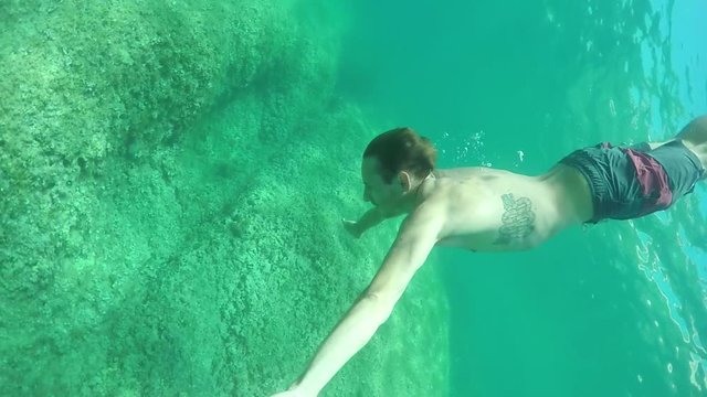SLOW MOTION: Powerful guy swimming freestyle stroke and exercising in the sea