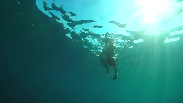 SLOW MOTION, CLOSE UP: Scared swimmer trying to escape from shark attacking him