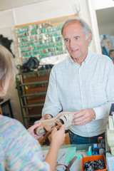 Customer passing shoe to cobbler