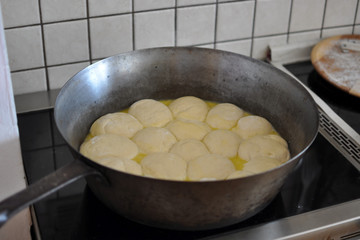 Dampfnudeln mit viel Butter in der traditionellen gußeisernen Dampfnudelpfanne