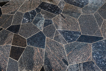 surface made of polygonal blocks of sanded grey and brown granit