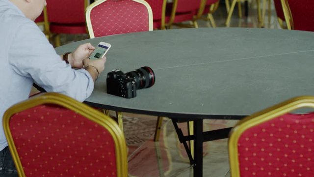 Man sitting at the table using iphone
