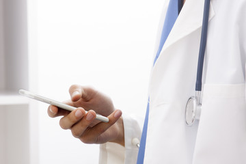 doctor with mobile phone in hands in office