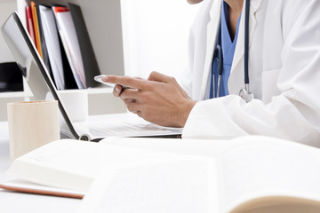 doctor with mobile phone in hands in office