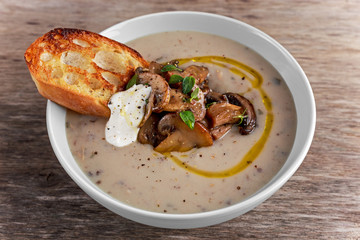 Mushroom soup with crouton and sour cream, olive oil