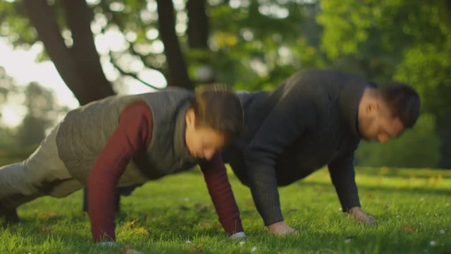 Father and Son Doing Push-ups in the Park. Shot on RED Cinema Camera in 4K (UHD) 