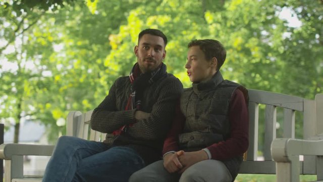 Father and Son Sitting on a Bench in the Park