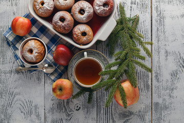 Traditional baked apple on a wooden table, with apple and powder
