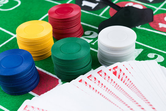 Casino chips and cards on green table.