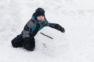 Fototapeta na wymiar child enjoys the winter and playing with snow