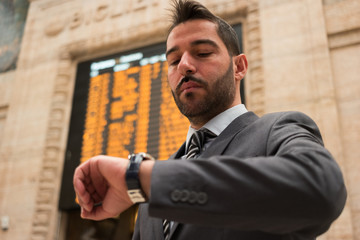 Man checking time in front of a timetable