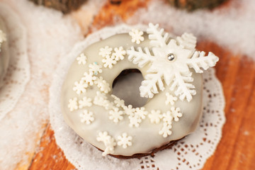 White donut decorated with a sugar snowflake.