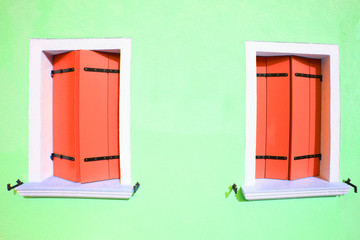 two windows in colorful house on the island of Burano in the in