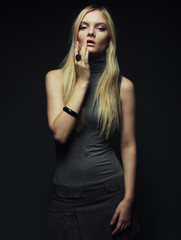 Portrait of beautiful young blonde girl in black dress. 