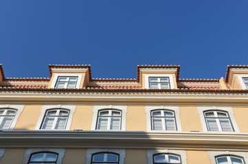 Fototapeta na wymiar Fenster an Hausfront mit blauem Himmel in Lissabon