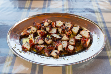 Greece style slice grill octopus  with olive oil on stainless steel plate in Thirasia  island, Greece