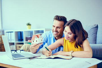 Happy couple creating new home design planning budget