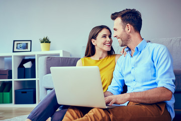Beautiful couple at home doing online shopping