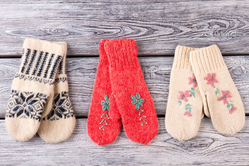Three colorful pairs of knitted handmade woolen mittens. - 126998084