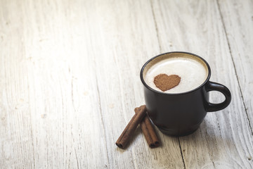 Coffee with cinnamon sticks and heart shape