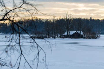 hut on island in the middle of a frozen lake in winter