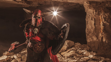 Attack of powerful knight in heavy armor on the dungeon backgrou