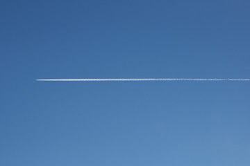 Airplane leave long white  trace on clear blue sky