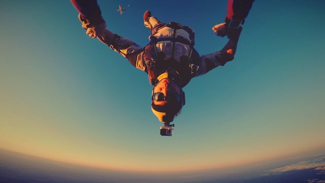 Skydiver at the sunset with plane and the moon behind