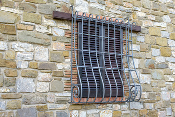 window with iron grating on stone wall - 127001035