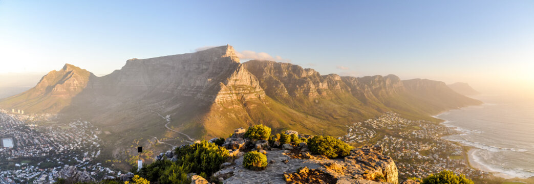 XXL panorama of Table Mountain and the Twelve Apostles mountain range seen from Lion's Head near Signal Hil in the evening sun. Camps Bay on the right, city of Cape Town on the left. South Africa.