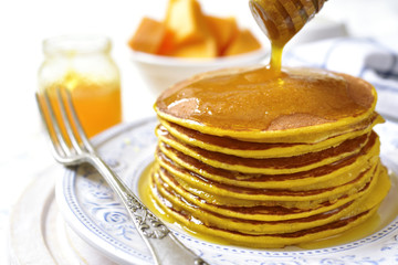 Pumpkin pancakes with honey for a breakfast.