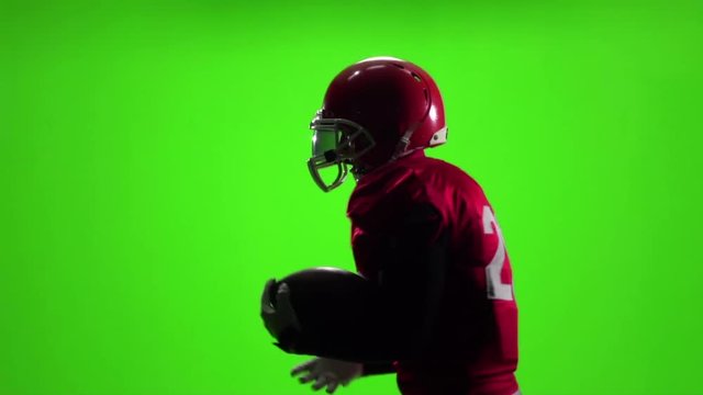 Athlete in red uniform with a ball. Slow motion. Side view. Green screen