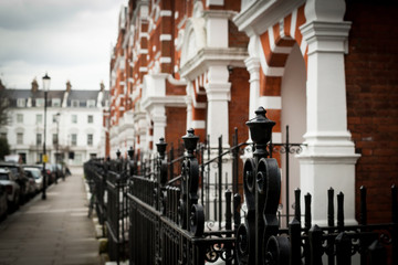 Fototapeta na wymiar Wicket to houses on blurred Kensington house facade, London