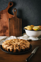 Homemade apple pie with nuts and cinnamon on dark background