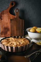 Homemade apple pie with nuts and cinnamon on dark background