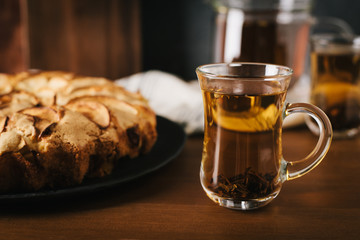 Homemade apple pie with nuts and cinnamon on dark background