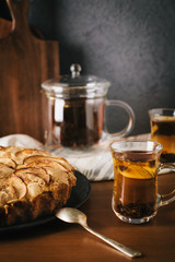 Homemade apple pie with nuts and cinnamon on dark background