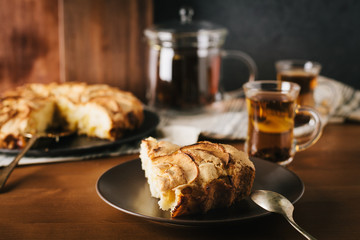 Homemade apple pie with nuts and cinnamon on dark background