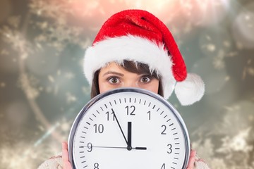 Anxious woman in santa hat holding a clock