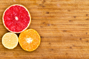 Fototapeta na wymiar Sliced Grapefruit, Orange and Lemon on Wood Board