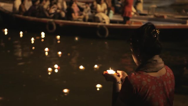 MS TU TD Woman putting offerings into Ganges river / Varanasi, India