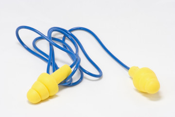 Yellow foam ear plugs with blue wire on white background.