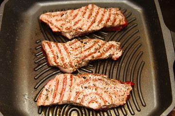 Slices of beef strip loin stir-fried in a skillet-grill, visible