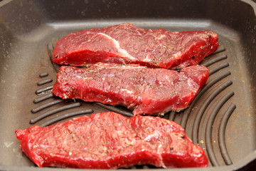 Slices of beef strip loin stir-fried in a skillet-grill, visible