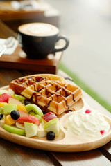 Waffle pour chocolate sauce and fruit mixed Served whipping cream and drink with Hot cappuchino for appetizer