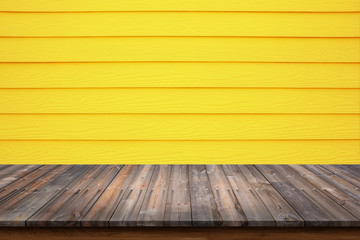 Wood table on yellow wood wall for background.