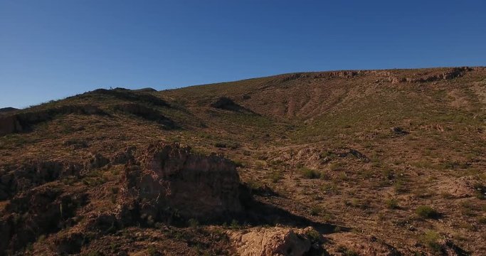 A high angle reverse aerial daytime flyover establishing shot of the Arizona desert.  	