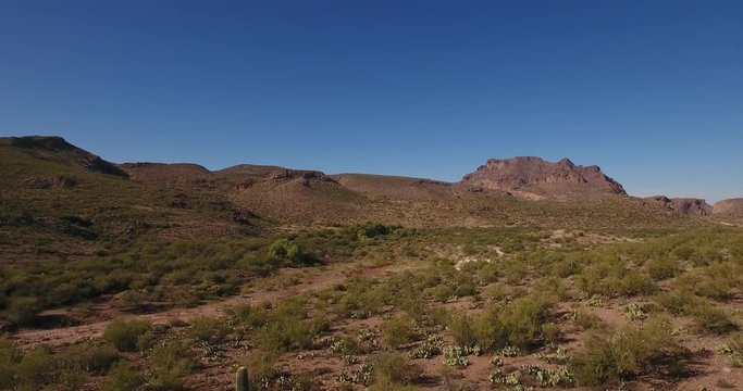 A high angle reverse aerial daytime flyover establishing shot of the Arizona desert.  	
