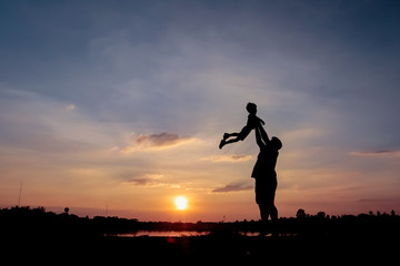 Family concept, Silhouette of father throwing son into the sky.